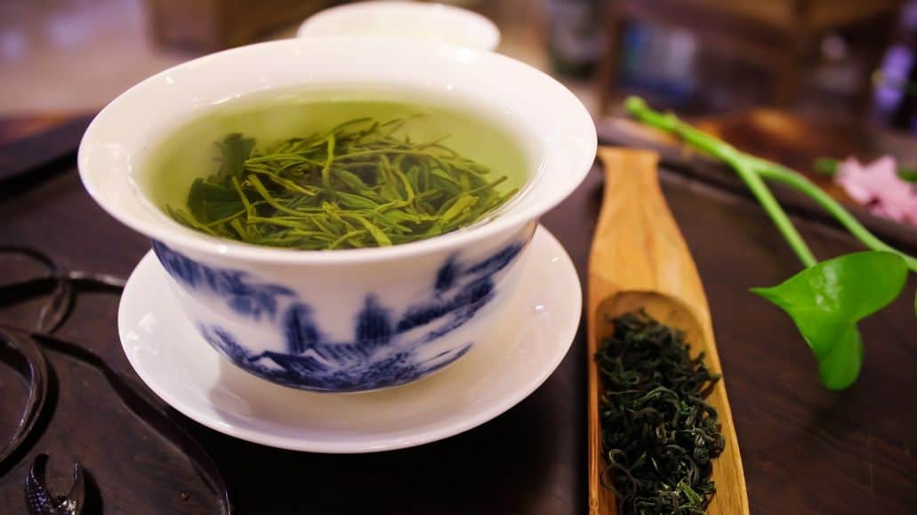 Cup of green tea with leaves