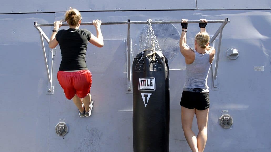 Two women doing a chin up and a pull up