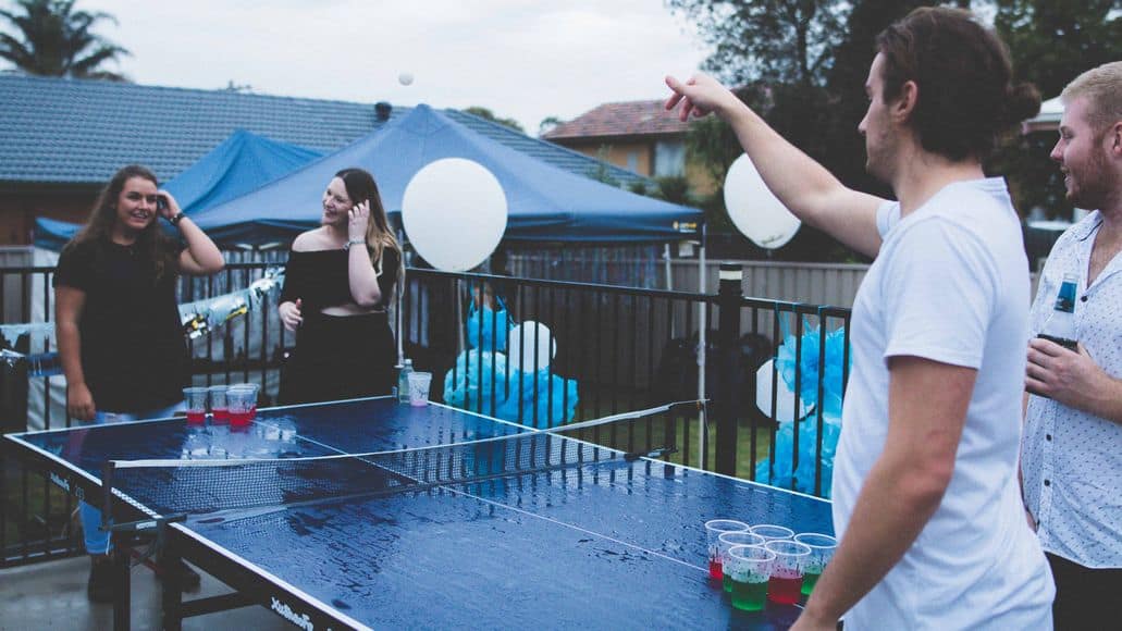 Four people playing beer pong