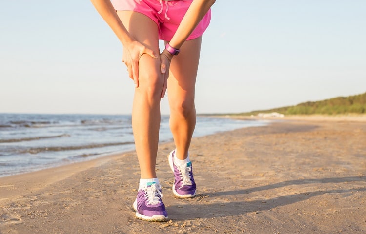 Woman holding her hurting knee